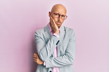 Bald man with beard wearing business clothes and glasses thinking looking tired and bored with depression problems with crossed arms.