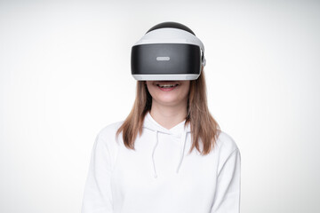 Studio portrait of a girl with long fair hair, happily watching something in testing VR glasses