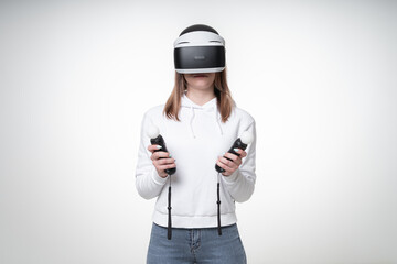 Young woman with long fair hair and white hoodie is playing VR game