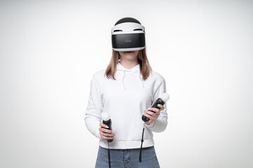Teenager with fair hair is playing playstation game with motion controllers, white studio background