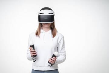 Teenager with fair hair is playing playstation game with motion controllers, white studio background