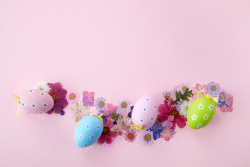 Fototapeta na wymiar Easter background. Frame of fllowers and eggs on pink background. Flat lay, top view