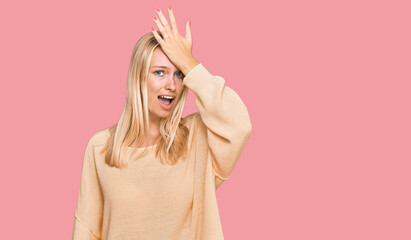 Young blonde girl wearing casual clothes surprised with hand on head for mistake, remember error. forgot, bad memory concept.