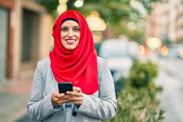 Young arab businesswoman wearing hijab using smartphone at the city.