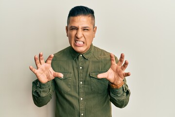 Young latin man wearing casual clothes smiling funny doing claw gesture as cat, aggressive and sexy...