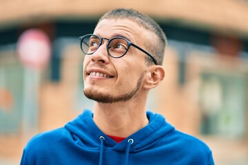 Obraz premium Young hispanic man smiling happy standing at the city.