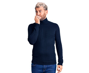 Young handsome blond man wearing casual turtleneck sweater looking stressed and nervous with hands on mouth biting nails. anxiety problem.