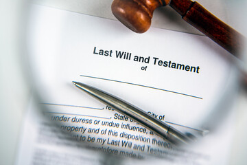 Last will and testament document form through magnifying glass.