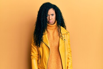 Middle age african american woman wearing wool winter sweater and leather jacket depressed and worry for distress, crying angry and afraid. sad expression.