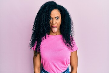 Middle age african american woman wearing casual clothes sticking tongue out happy with funny expression. emotion concept.