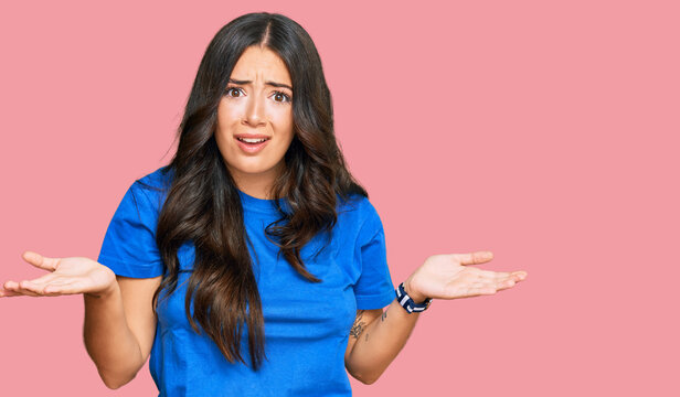 Beautiful brunette young woman wearing casual clothes clueless and confused with open arms, no idea concept.