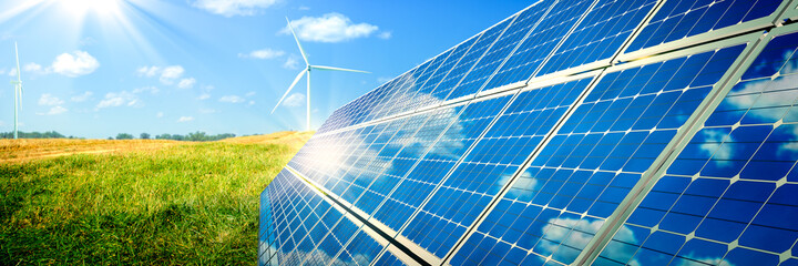 Fototapeta Solar Panels And Wind Turbines In Grassy Field With Sunlight - Renewable Energy Concept obraz