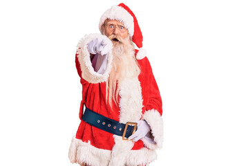 Old senior man with grey hair and long beard wearing traditional santa claus costume pointing displeased and frustrated to the camera, angry and furious with you