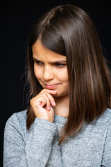 Girl, schoolgirl meditates, expresses emotions, close-up on a black background