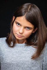 Girl, schoolgirl meditates, expresses emotions, close-up on a black background