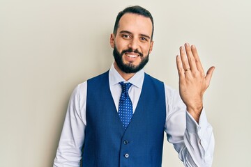 Young man with beard wearing engagement ring looking positive and happy standing and smiling with a confident smile showing teeth