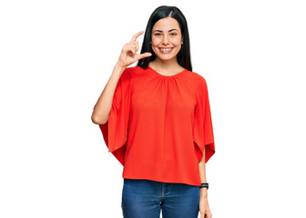 Beautiful young woman wearing casual clothes smiling and confident gesturing with hand doing small size sign with fingers looking and the camera. measure concept.