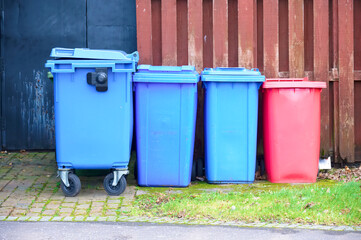 Wheelie bin colour blue, purple and black for refuge collection outside house in a row