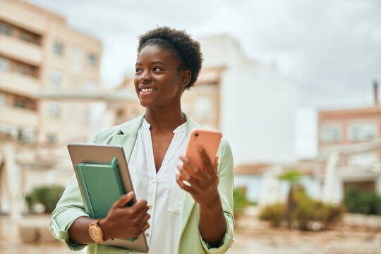 Young african american businesswoman smiling happy using smartphone at the city.