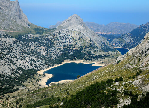 Spectacular View From The Summit Of Mount L'Ofre To The Puig Major And The Marine Blue Lake Cuber In The Tramuntana Mountains On Balearic Island Mallorca On A Sunny Winter Day With A Clear Blue Sky