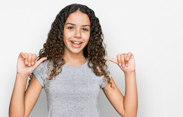 Teenager hispanic girl wearing casual clothes looking confident with smile on face, pointing oneself with fingers proud and happy.