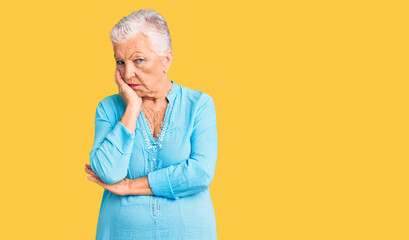 Senior beautiful woman with blue eyes and grey hair wearing summer dress thinking looking tired and bored with depression problems with crossed arms.