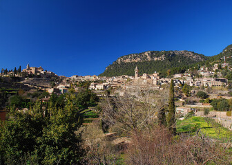 Fototapeta na wymiar View To The Picturesque Village Of Valldemossa Within The Mountainous Landscape Of Tramuntana On Balearic Island Mallorca On A Sunny Winter Day With A Clear Blue Sky