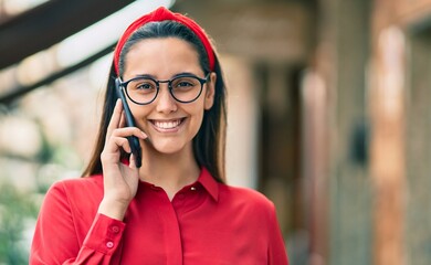 Young hispanic woman smiling happy talking on the smartphone at the city.