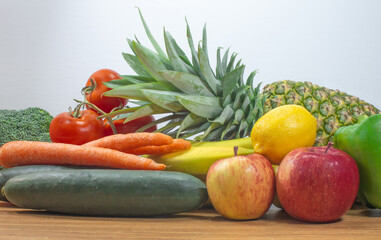 assortment of fruits and vegetables placed horizontally on a brown wooden table