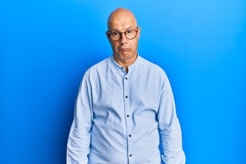 Middle age bald man wearing casual clothes and glasses depressed and worry for distress, crying angry and afraid. sad expression.