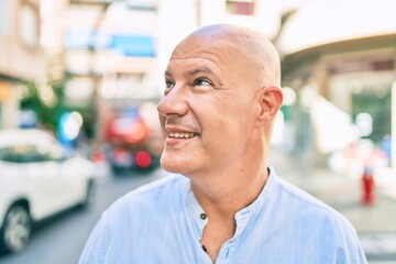 Fototapeta na wymiar Middle age bald man smiling happy walking at the city.