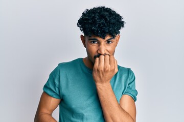 Fototapeta na wymiar Young arab handsome man wearing casual clothes looking stressed and nervous with hands on mouth biting nails. anxiety problem.
