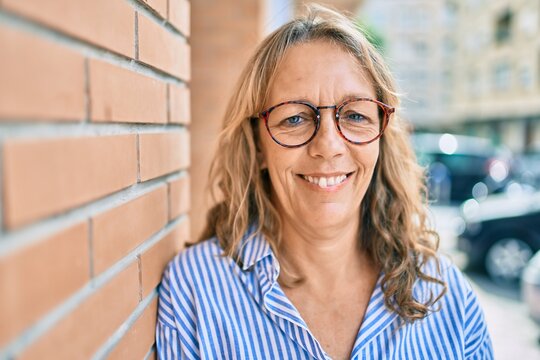 Middle age caucasian woman smiling happy standing at the city.