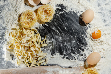 Pasta cooking ingredients on black kitchen table. Top view with space for your text
