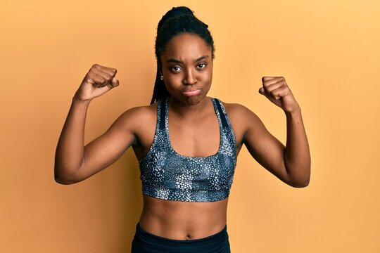 African american woman with braided hair wearing sportswear showing arm muscles depressed and worry for distress, crying angry and afraid. sad expression.