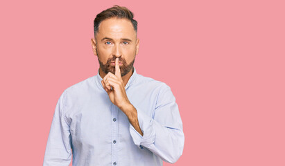 Handsome middle age man wearing business shirt asking to be quiet with finger on lips. silence and secret concept. - obrazy, fototapety, plakaty