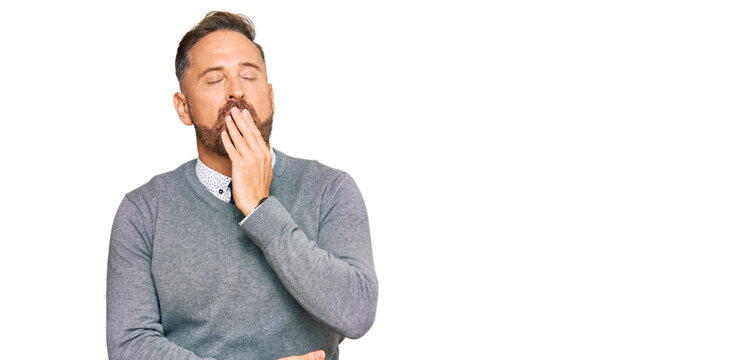 Handsome middle age man wearing business clothes bored yawning tired covering mouth with hand. restless and sleepiness.