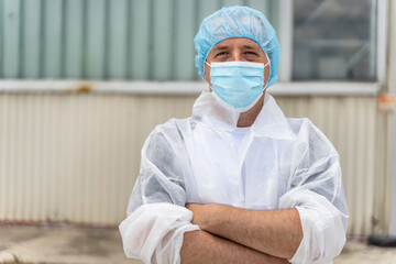 Portrait of caucasian man wearing protective mask and bouffant mob cap - Young male doctor or...