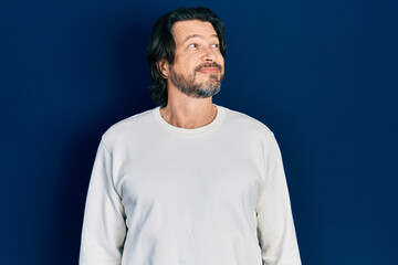 Fototapeta premium Middle age caucasian man wearing casual clothes smiling looking to the side and staring away thinking.