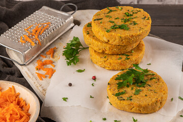 Raw veggie burger with chickpeas, vegetables and parsley leaves on kitchen countertop