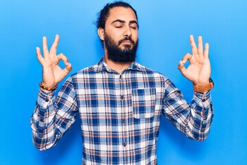 Naklejka premium Young arab man wearing casual clothes relax and smiling with eyes closed doing meditation gesture with fingers. yoga concept.