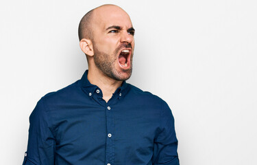 Fototapeta premium Young hispanic man wearing casual clothes angry and mad screaming frustrated and furious, shouting with anger. rage and aggressive concept.