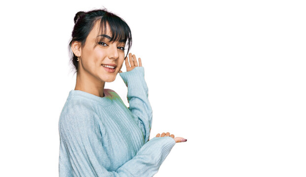 Young hispanic woman wearing casual clothes inviting to enter smiling natural with open hand