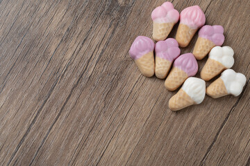 Pink white icecream shape jellybeans on a wooden board