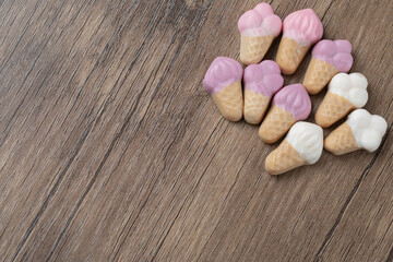 Fototapeta na wymiar Pink white icecream shape jellybeans on a wooden board