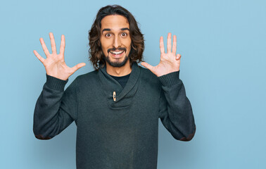 Young hispanic man wearing casual clothes showing and pointing up with fingers number nine while...