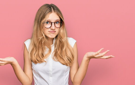 Beautiful young caucasian girl wearing casual clothes and glasses clueless and confused expression with arms and hands raised. doubt concept.