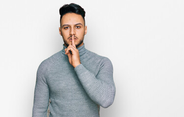 Young arab man wearing casual clothes asking to be quiet with finger on lips. silence and secret...