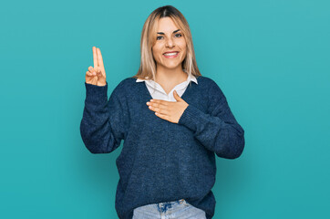 Young caucasian woman wearing casual clothes smiling swearing with hand on chest and fingers up,...