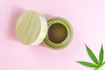 Obraz na płótnie Canvas Full Spectrum CBD cannabis alternative medicine skincare cream in glass jar isolated on pink